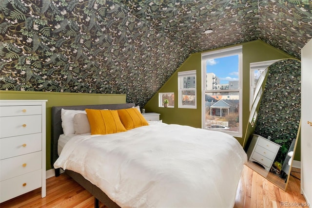 bedroom featuring lofted ceiling and wood finished floors