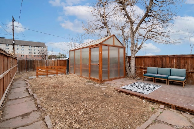 view of greenhouse featuring outdoor lounge area and a fenced backyard