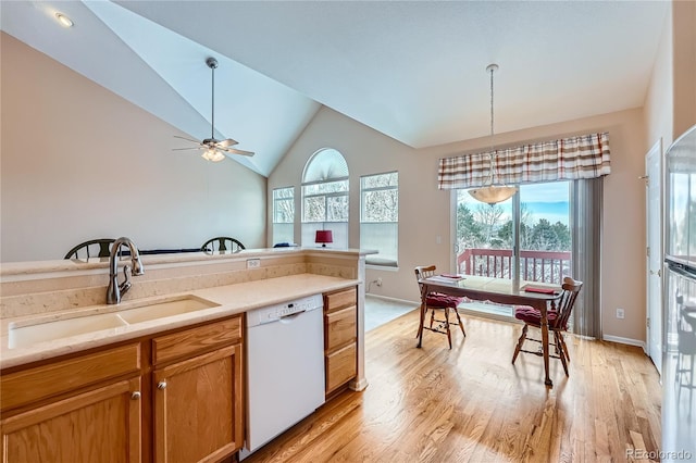 kitchen with sink, vaulted ceiling, ceiling fan, white dishwasher, and pendant lighting