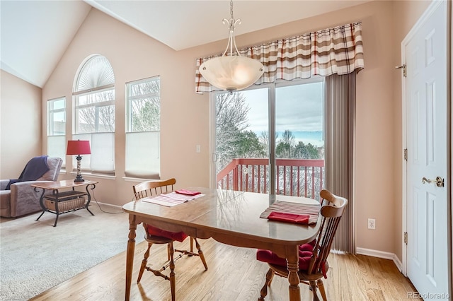 dining room with vaulted ceiling and light hardwood / wood-style floors