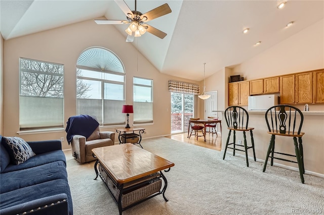 living room with high vaulted ceiling, light carpet, and ceiling fan