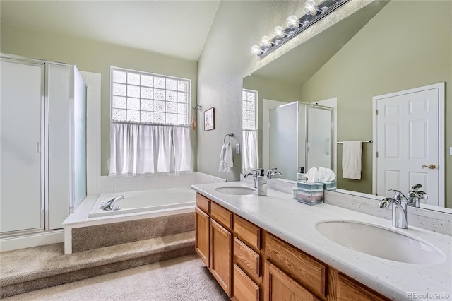 bathroom with independent shower and bath, vaulted ceiling, and vanity