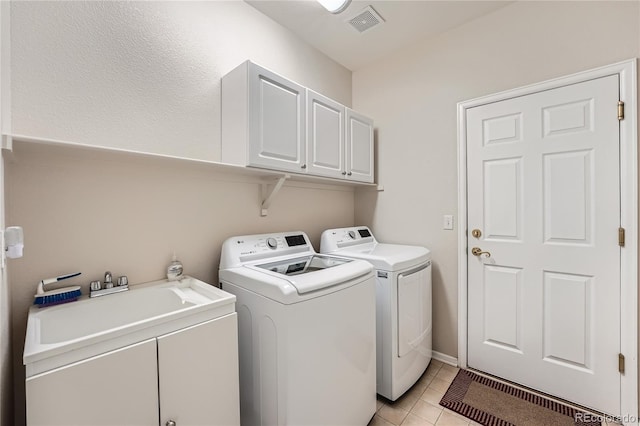 laundry room with washing machine and dryer, cabinets, light tile patterned floors, and sink