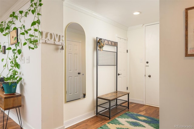 corridor with ornamental molding and hardwood / wood-style floors