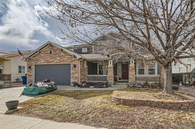 view of front facade featuring driveway, a garage, stone siding, covered porch, and fence