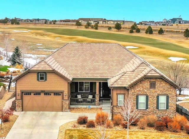 view of front of home with stone siding, golf course view, and covered porch