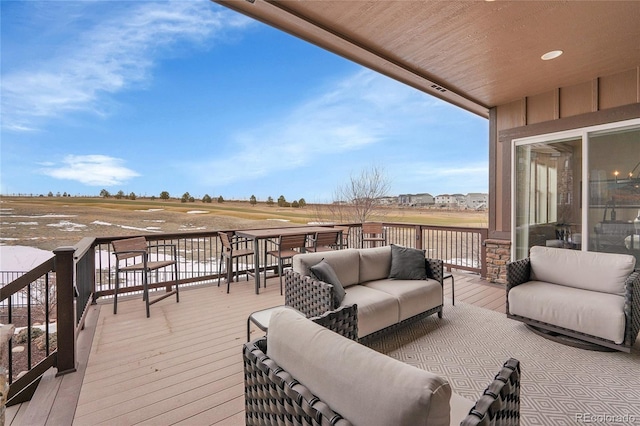 wooden terrace with an outdoor living space