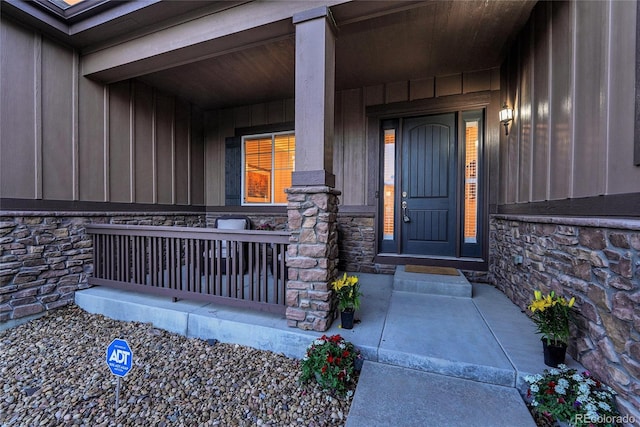 27615 E Moraine Dr, Aurora, CO 80016 - doorway to property featuring stone siding, a porch, and board and batten siding