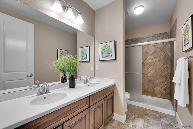 27615 E Moraine Dr, Aurora, CO 80016 - full bathroom featuring toilet, double vanity, a shower stall, and baseboards