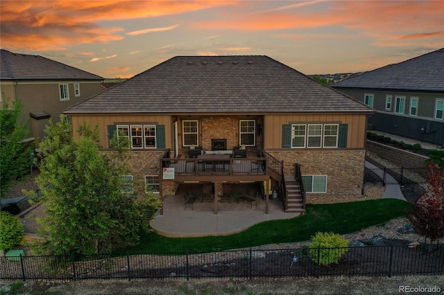 27615 E Moraine Dr, Aurora, CO 80016 - back of property at dusk with stairway, stone siding, a wooden deck, a patio, and board and batten siding