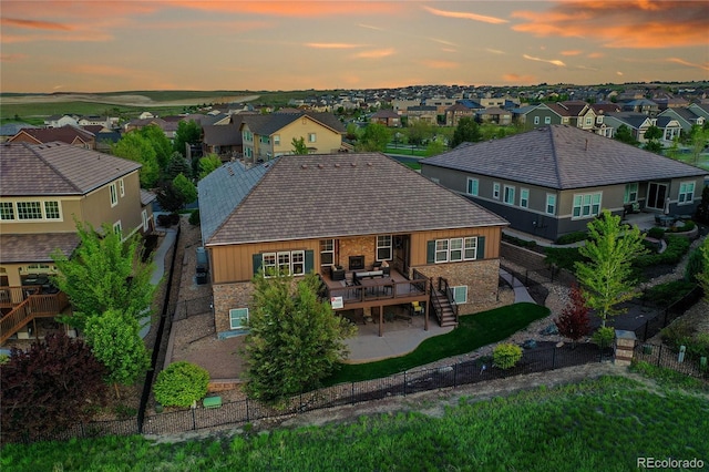 27615 E Moraine Dr, Aurora, CO 80016 - back of house at dusk featuring stairs, a residential view, a deck, a fenced backyard, and brick siding