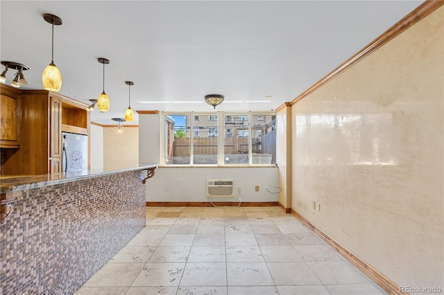1196 N Grant St Unit 106, Denver, CO 80203 - kitchen featuring refrigerator, a wall mounted AC, hanging light fixtures, and brown cabinets