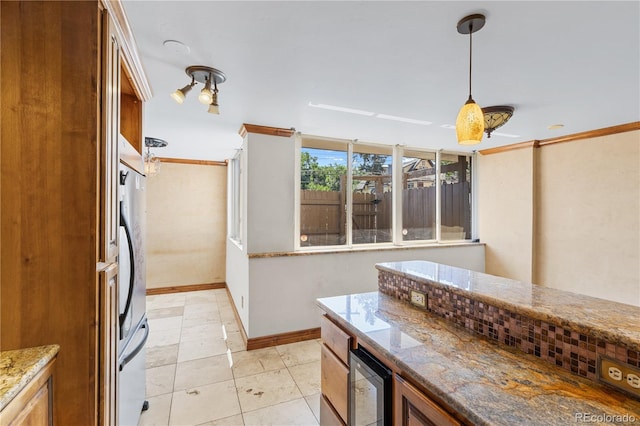 1196 N Grant St Unit 106, Denver, CO 80203 - kitchen with ornamental molding, light stone counters, pendant lighting, brown cabinets, and wine cooler