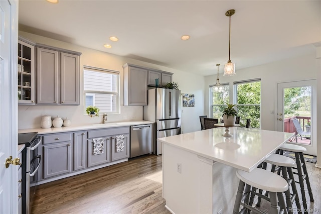 15649 E 7th Cir, Aurora, CO 80011 - kitchen with stainless steel appliances, gray cabinets, a breakfast bar area, and recessed lighting