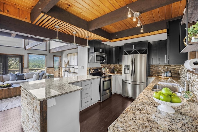 4477 Independence Trl, Evergreen, CO 80439 - kitchen with appliances with stainless steel finishes, dark cabinetry, a wooden ceiling with exposed beams, a peninsula, and dark wood-style flooring