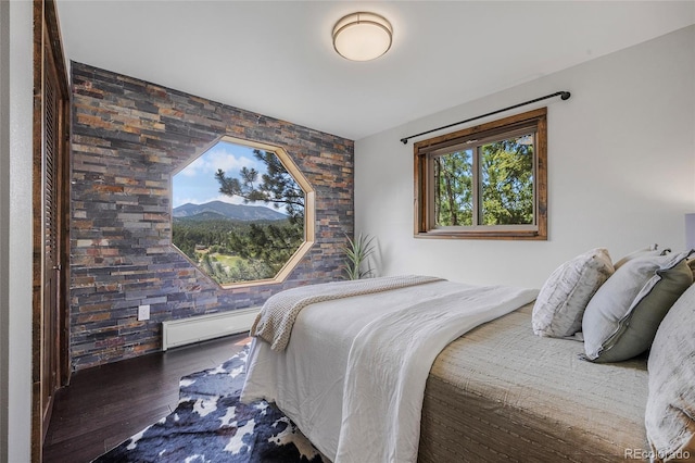 4477 Independence Trl, Evergreen, CO 80439 - bedroom with wood finished floors, baseboard heating, and an accent wall