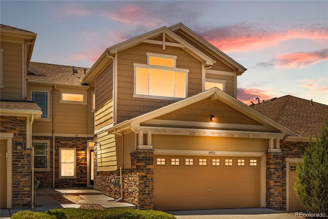 14892 E Poundstone Dr, Aurora, CO 80015 - view of front facade with stone siding, an attached garage, driveway, and a shingled roof