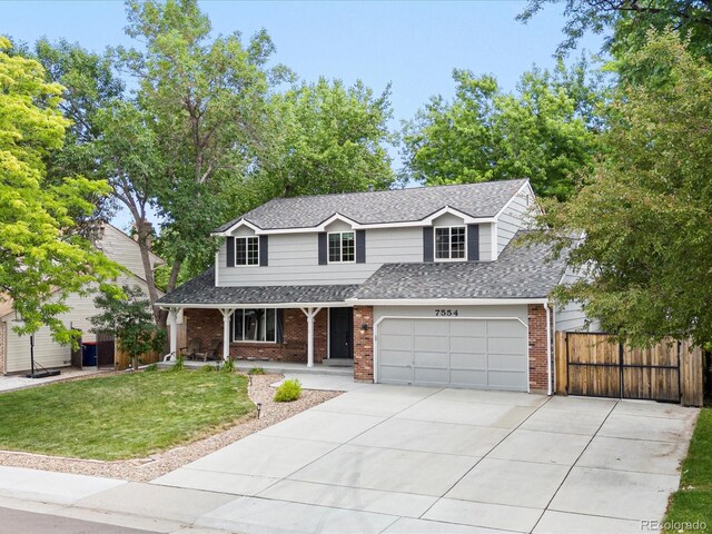 7554 S Ogden Way, Centennial, CO 80122 - traditional-style house featuring covered porch, brick siding, roof with shingles, and driveway