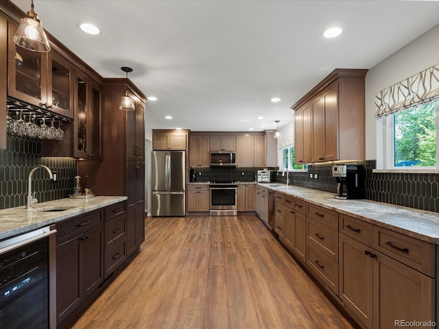 7554 S Ogden Way, Centennial, CO 80122 - kitchen featuring appliances with stainless steel finishes, beverage cooler, plenty of natural light, backsplash, and recessed lighting