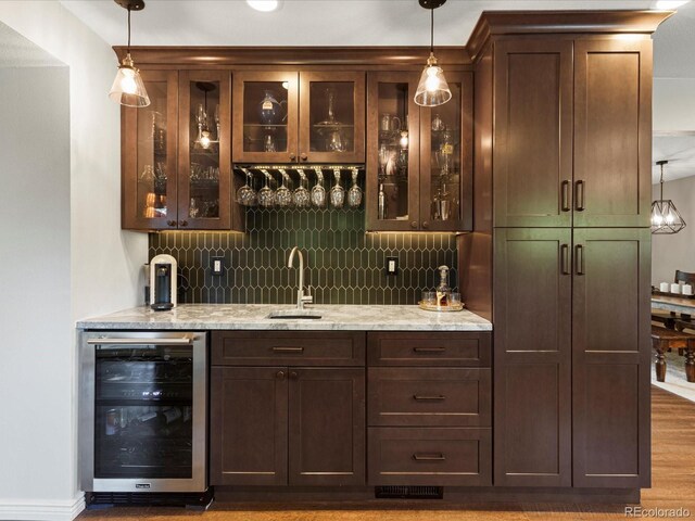 7554 S Ogden Way, Centennial, CO 80122 - indoor wet bar featuring wine cooler, tasteful backsplash, and hanging light fixtures