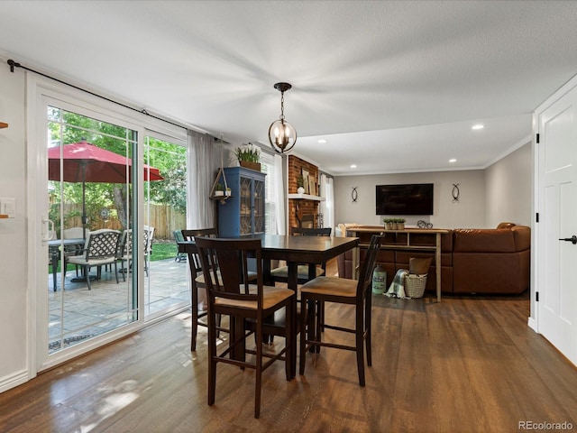 7554 S Ogden Way, Centennial, CO 80122 - dining room with dark wood-type flooring, recessed lighting, a chandelier, a brick fireplace, and ornamental molding