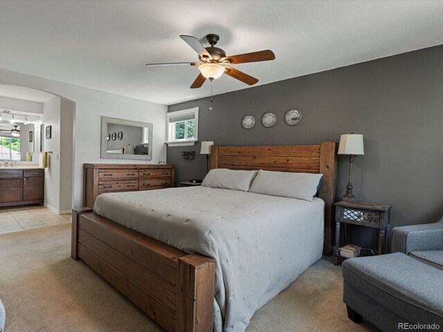 7554 S Ogden Way, Centennial, CO 80122 - bedroom featuring light carpet, multiple windows, arched walkways, and connected bathroom