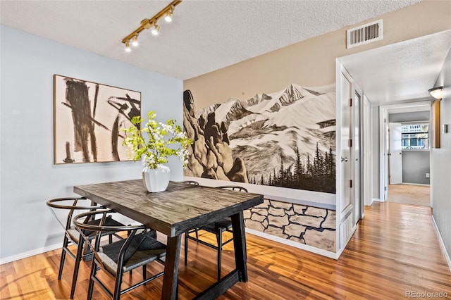 dining room with a textured ceiling and hardwood / wood-style flooring