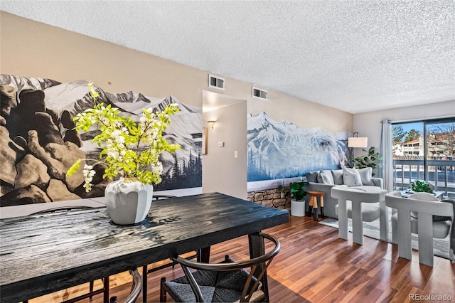 dining space featuring a textured ceiling and dark hardwood / wood-style flooring