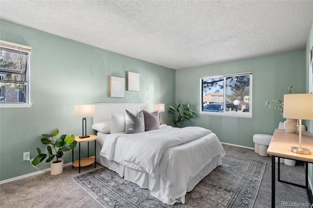 carpeted bedroom featuring a textured ceiling and multiple windows