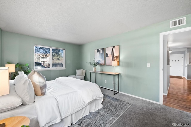 bedroom featuring carpet flooring and a textured ceiling