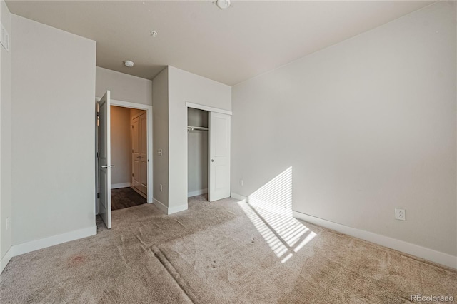 unfurnished bedroom with light carpet and a closet