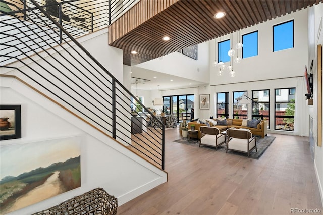 staircase with a wealth of natural light, wood-type flooring, and a high ceiling