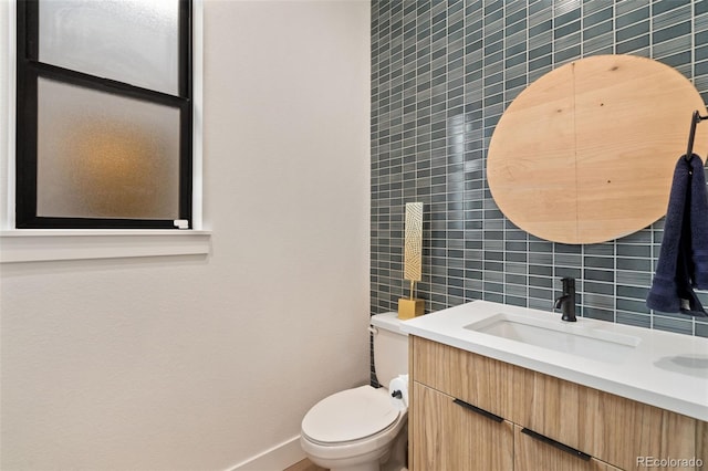 bathroom featuring vanity, toilet, decorative backsplash, and tile walls