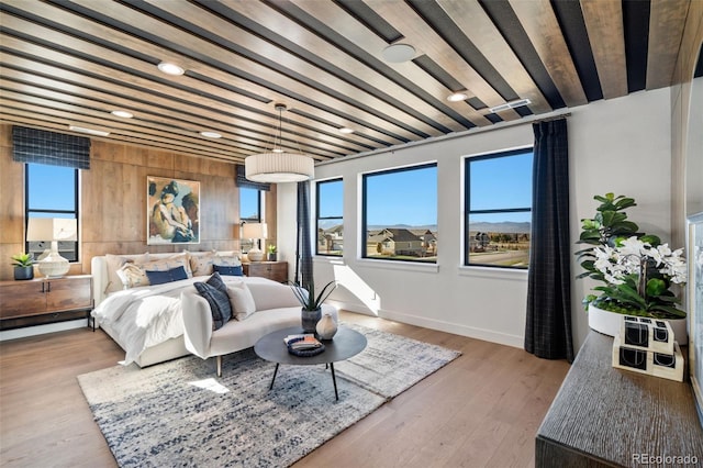 bedroom featuring beamed ceiling and light hardwood / wood-style flooring