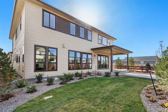 rear view of property with a lawn and a patio area