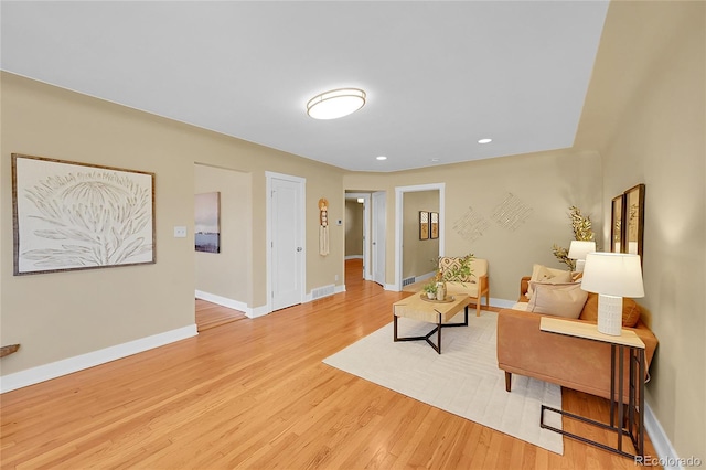 living area featuring light wood finished floors, visible vents, baseboards, and recessed lighting