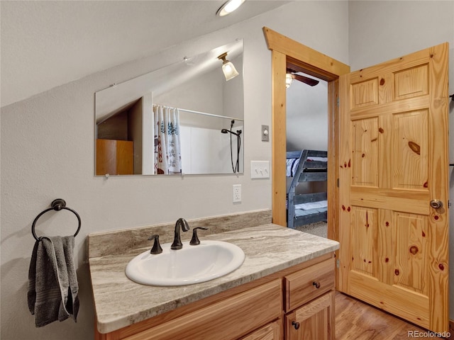 bathroom with lofted ceiling, vanity, a shower with shower curtain, and hardwood / wood-style floors