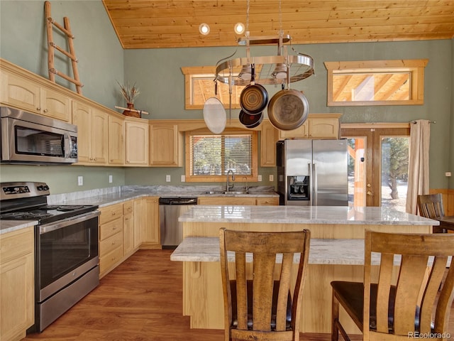 kitchen with appliances with stainless steel finishes, sink, a center island, light brown cabinets, and wooden ceiling