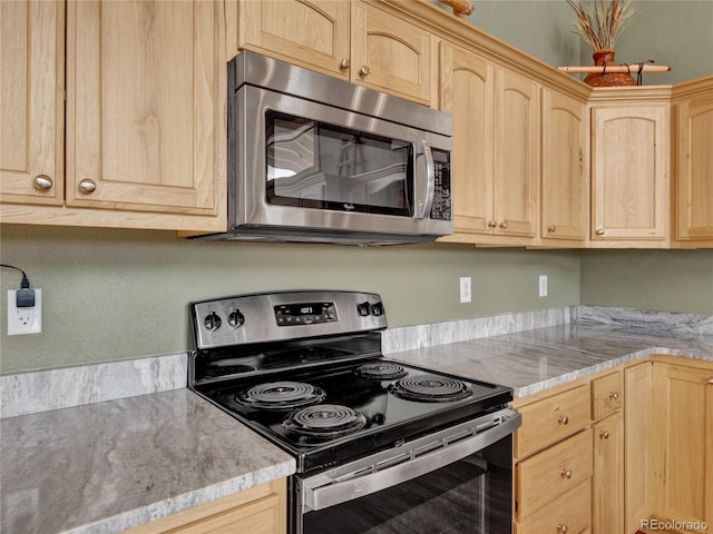 kitchen featuring appliances with stainless steel finishes, light stone counters, and light brown cabinetry