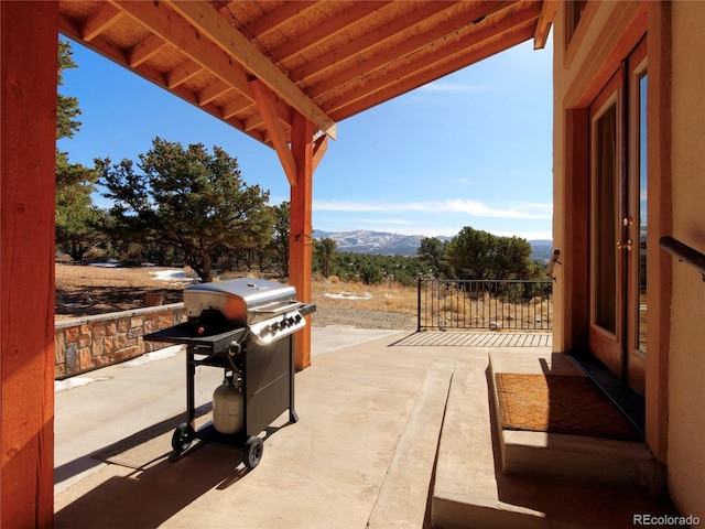 view of patio with a mountain view and a grill