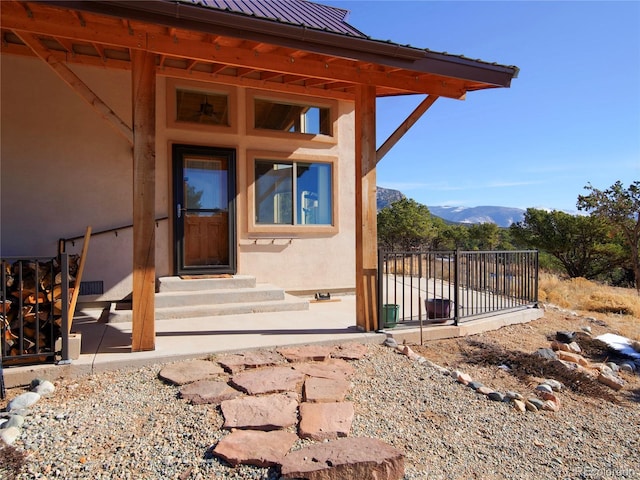 view of exterior entry with a mountain view and a patio area