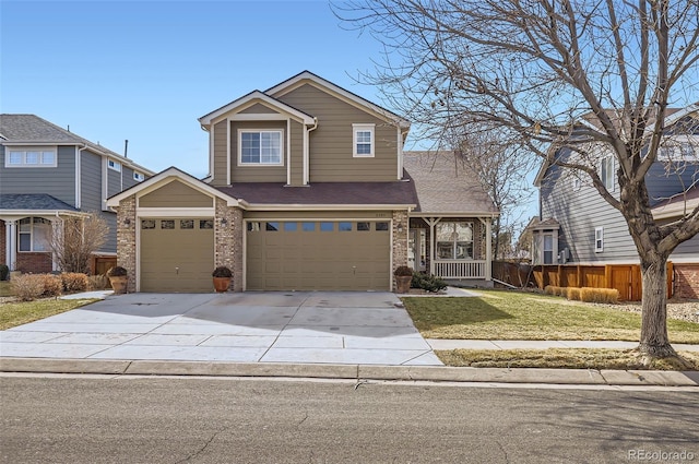 traditional-style house with driveway, brick siding, a front yard, and fence