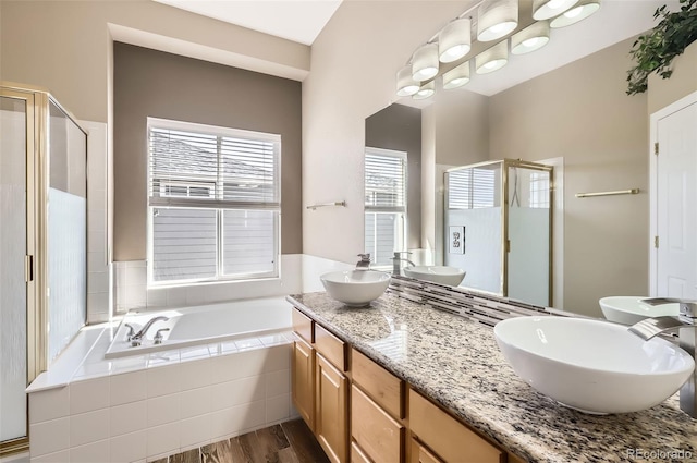 full bath with a stall shower, plenty of natural light, a sink, and a bath