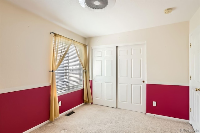 bedroom featuring a closet, carpet flooring, visible vents, and baseboards