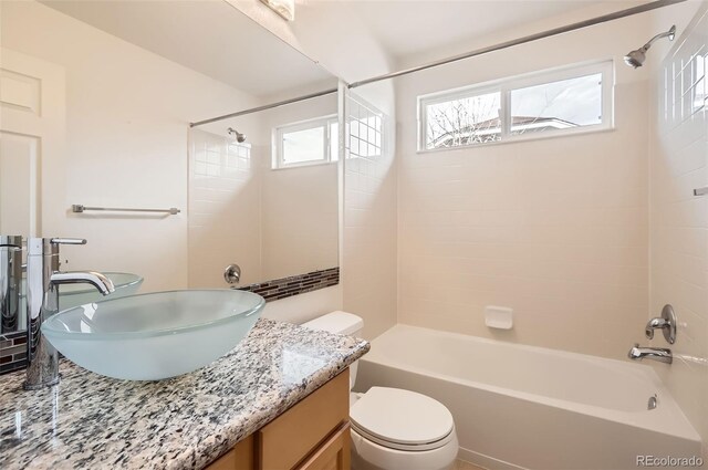 bathroom with tub / shower combination, vanity, and toilet