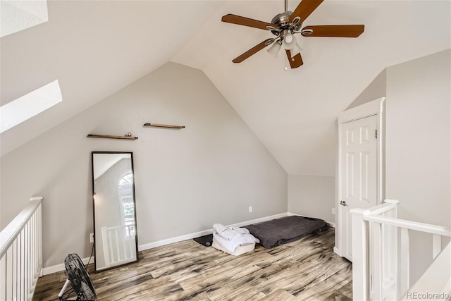 bonus room featuring lofted ceiling with skylight and light wood-type flooring