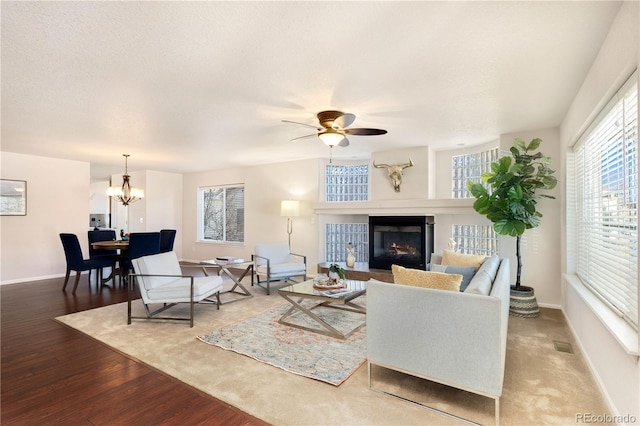 living room featuring ceiling fan with notable chandelier, hardwood / wood-style floors, and plenty of natural light