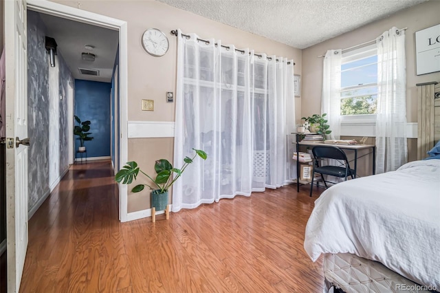 bedroom featuring a textured ceiling and hardwood / wood-style floors