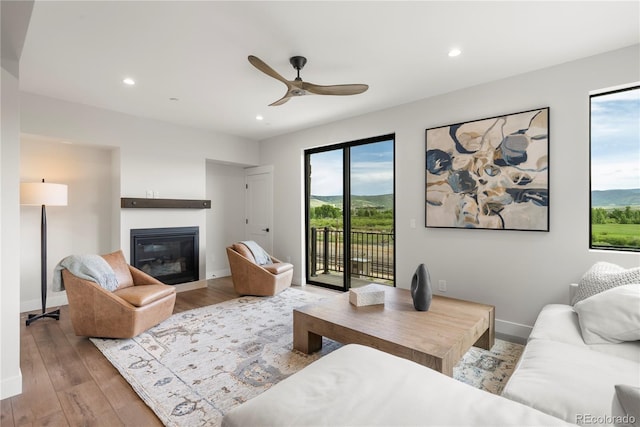 living room featuring ceiling fan and light hardwood / wood-style flooring