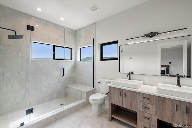 bathroom with tile patterned flooring, vanity, toilet, and a shower with shower door